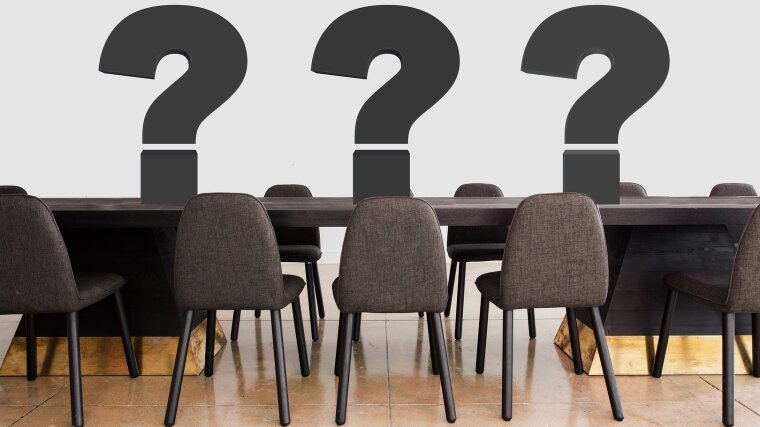 Symbolbild Konferenz: Ein Tisch mit mehreren Stühlen.
