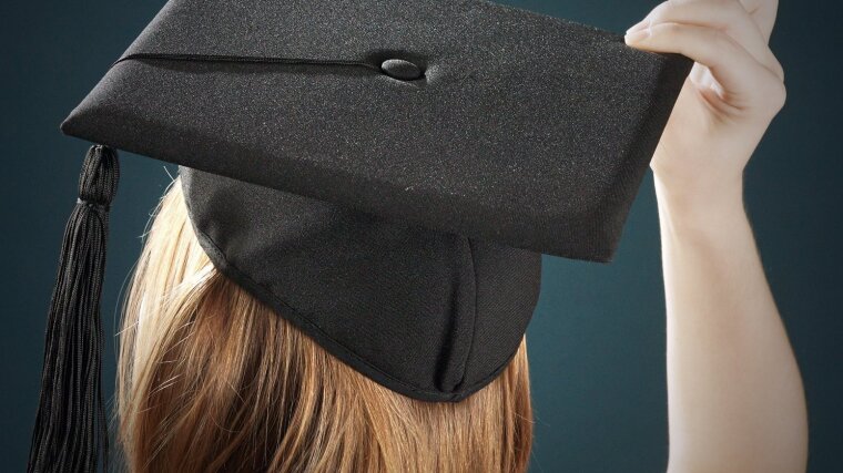Eine junge Frau mit einem Doktorhut.