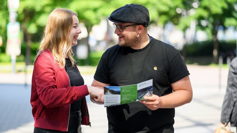 Zwei Geographie-Studierende mit einem Flyer zum Studiengang