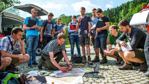 Studierende der Geowissenschaften und ein Gerologie-Professor der Universität Jena studieren im Gelände geologische Karten.