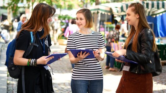 Three geography students are talking to each other.